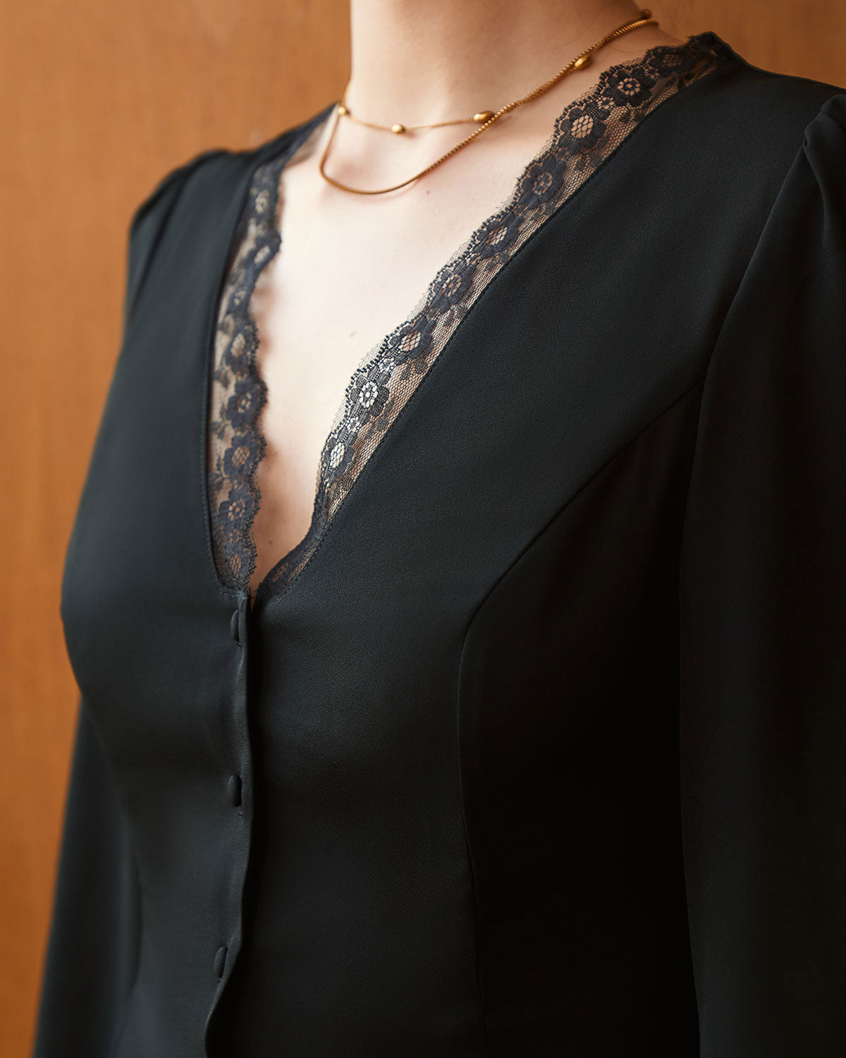 Ella Paris™ | La blouse noire à col en V avec boutons et bordure en dentelle
